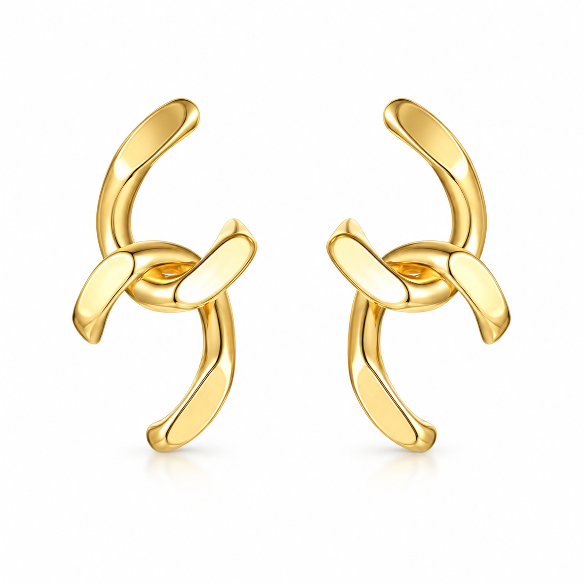 Gold-tone sculptural knot statement earrings on white background