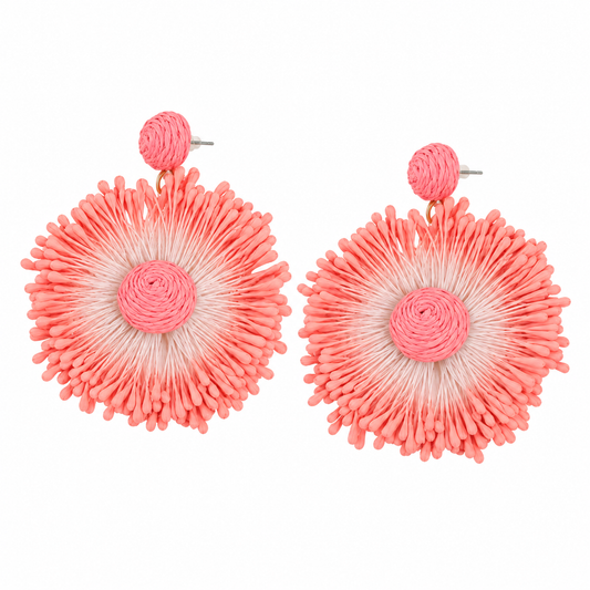 Coral woven sunburst statement earrings on white background